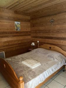 a bedroom with a bed in a log cabin at Chalet Robin (6 personnes) in La Lechere