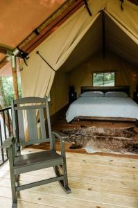 a bed and a chair in a tent at GlampKnox Canvas Campground - Tree Solo in Knoxville +36 photos