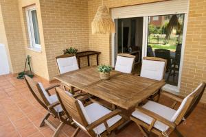 a wooden table and chairs on a patio at Apartamento Olimpic Beach in Roquetas de Mar