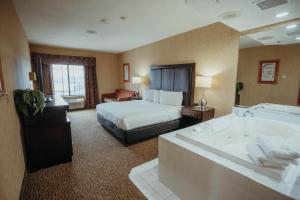 a hotel room with a bed and a bath tub at Wildwood Lodge in Pewaukee