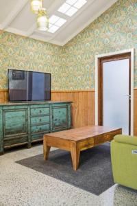 a living room with a tv and a coffee table at Chic Converted Barn in Matakana with Spa in Big Omaha