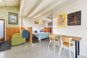 a bedroom with a bed and a table and chairs at Chic Converted Barn in Matakana with Spa in Big Omaha