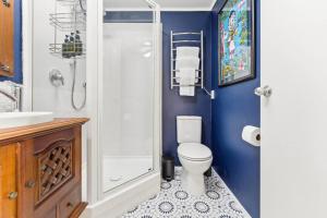 a bathroom with a white toilet and a shower at Chic Converted Barn in Matakana with Spa in Big Omaha +16 photos