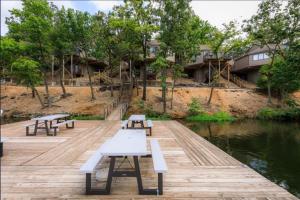a group of benches sitting on a dock next to the water at Sunbeam Shores 3Bed 3 Bath Pool-6PP in Osage Beach
