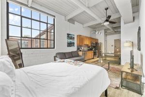 a bedroom with a large white bed and a kitchen at 2125 Superior Living in Cleveland
