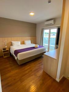 a bedroom with a large bed and a window at Legacy Hotel Guaratinguetá - Ao lado de Aparecida -SP in Guaratinguetá