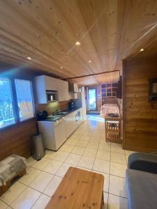 a large kitchen with a wooden ceiling and a table at Chalet Robin (6 personnes) in La Lechere