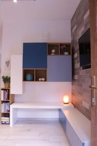 a living room with a white bench and a tv at Levico Nature Escape in Levico Terme