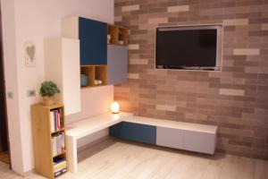 a living room with a tv on a brick wall at Levico Nature Escape in Levico Terme