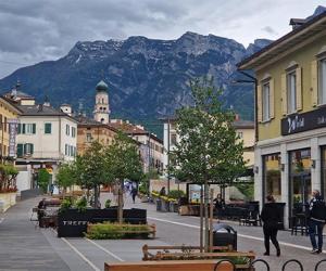 a street in a town with a mountain in the background at Levico Nature Escape in Levico Terme