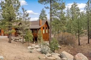 a log cabin in the woods with trees at Bear Creek Lodge with Hot Tub in Big Bear Lake
