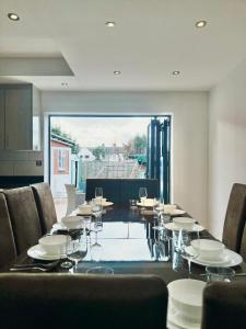 a dining room with a long table and chairs at Gants Hill House in Redbridge