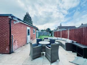 a patio with a table and chairs and a couch at Gants Hill House in Redbridge