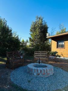 a fire hydrant and two benches in a yard at El Descanso Cabins in Capilla Palacio