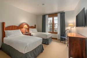 a hotel room with two beds and a television at Teton Club in Teton Village