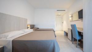 a bedroom with a bed and a desk with a blue chair at Nuovo Hotel SettiBi in Giulianova +5 photos