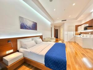 a bedroom with a large bed and a kitchen at Condo Studio Plaza in Budva