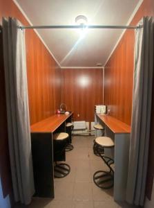 a bathroom with desks and stools in a room at Мужской Хостел in Astana