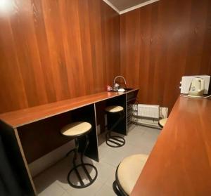 a room with a counter and stools in a room at Мужской Хостел in Astana