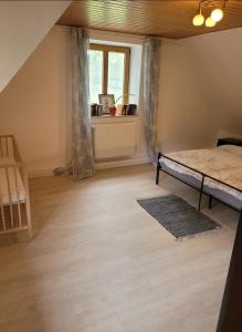 an attic room with a bed and a window at Oakwoods in Holste