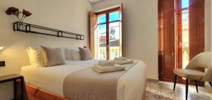 a bedroom with a large bed with towels on it at Zalamera BnB in Valencia