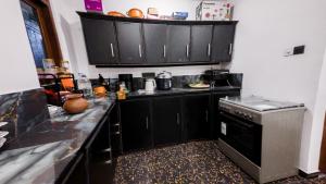a kitchen with black cabinets and a stove at SouthStone Paradise in Balapitiya