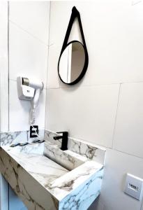 a bathroom with a mirror and a sink at Charlotte Beach Inn in Mangaratiba