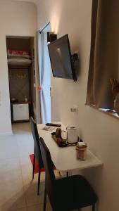 a table with two chairs and a tv on the wall at B&B Matt Ros in Noto