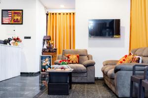 a living room with two couches and a tv at SouthStone Paradise in Balapitiya