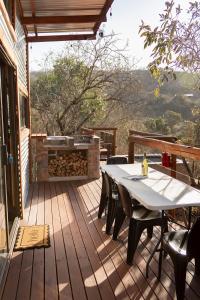 a wooden deck with a table and chairs and a grill at De Dek Venue & Accommodation in Guthrie