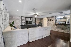 a living room with two white couches and a brick wall at Villa Manteago in Bradenton