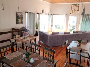 a living room with tables and chairs and a couch at Seaview Sunsets in Gqeberha