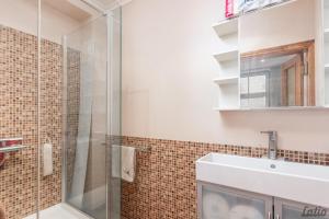 a bathroom with a glass shower and a sink at City Centre Cozy Guesthouse in Riga