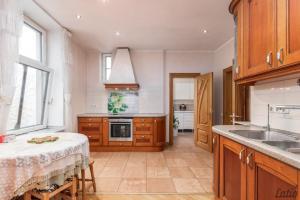 a kitchen with wooden cabinets and a sink and a table at City Centre Cozy Guesthouse in Riga +15 photos