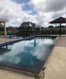a pool with blue water and an umbrella at Flat Cerejeiras - Condomínio Privado in Bananeiras