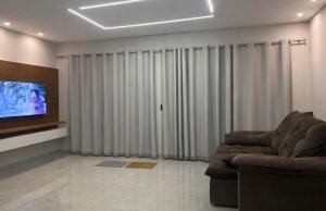 a living room with a couch and a flat screen tv at Flat Cerejeiras - Condomínio Privado in Bananeiras +12 photos