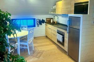 a kitchen with a table and a stainless steel refrigerator at Studio Svartbygget in Åre