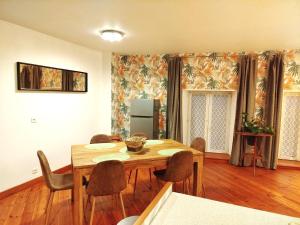 a dining room with a wooden table and chairs at CHEZ CELINE en campagne in Mazerny