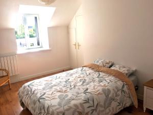 a bedroom with a bed and a window at Gîte La Dame du Lac in Paimpont