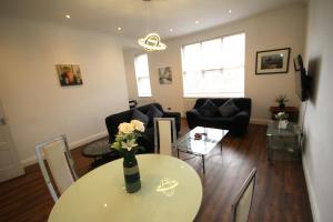 a living room with a table with a vase of flowers on it at Isleworth Apt C in Hounslow