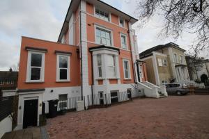 an orange and white house on a brick street at Isleworth Apt C in Hounslow