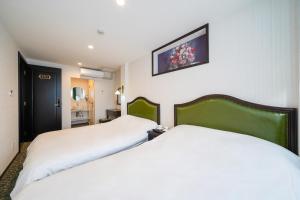a hotel room with two beds and a picture on the wall at 大同GardenHotel 大阪西九条 本館 in Osaka