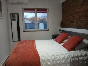 a bedroom with a large white bed with red pillows at Gite de PHAM in Belberaud