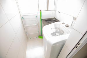 a small white bathroom with a sink and a window at Jahu Center Casas Un 2 in Jaú +52 photos