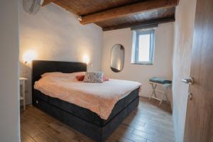 a bedroom with a bed in a room with a window at Le Case di Rosie, Tuscan Mountain View apartment, Pool in Gragnola