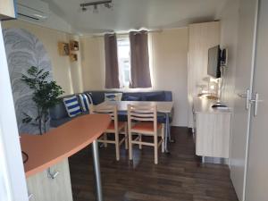 a small kitchen and dining room with a table and chairs at Mobil home YANN in Sainte-Croix-de-Verdon