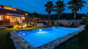 a swimming pool in the yard of a house at night at Villa Sitges El Olivo High Comodity AC Pool Heated 30º Optional Real Garden Pool XXL 10 min drive from Sitges in Olivella