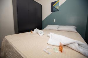 a bedroom with two beds with towels on the bed at Jahu Center Casas Un 2 in Jaú