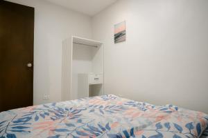 a bedroom with a bed with a colorful comforter at Joanna Transient Home in Palestina