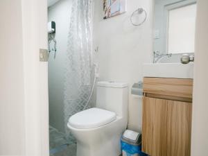 a bathroom with a white toilet and a shower at Joanna Transient Home in Palestina +12 photos